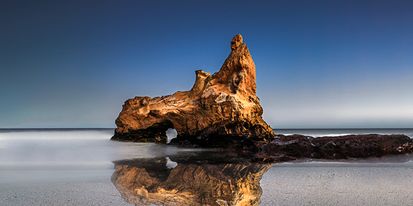 Foto de una playa con un gran roca, hecha por Gabriel D´Agostino